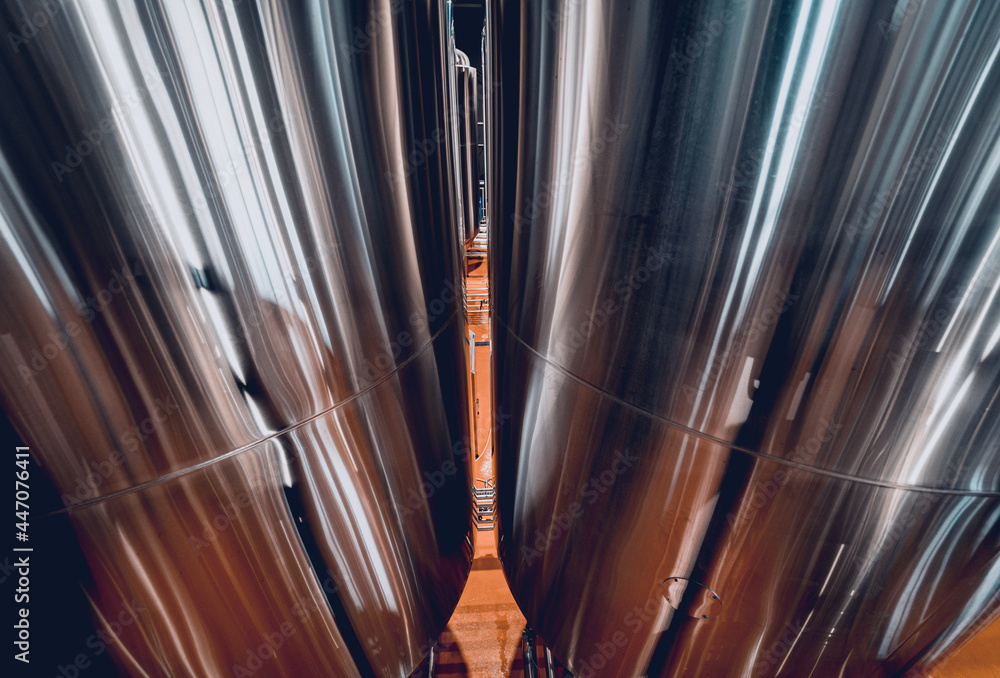 Rows of steel tanks for beer fermentation and maturation in a craft brewery Rows of steel tanks for beer fermentation and maturation in a craft brewery