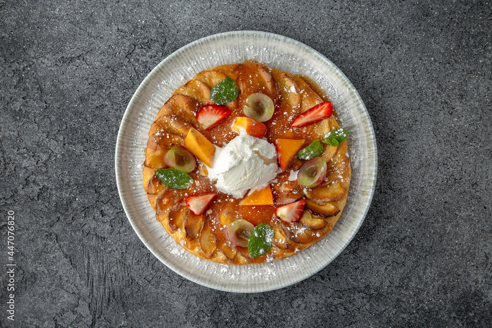 Apple pie decorated with peach and berries. Dessert. Ready menu for the restaurant. Neutral gray blue textured background. Apple pie decorated with peach and berries. Dessert. Ready menu for the restaurant. Neutral gray blue textured background.