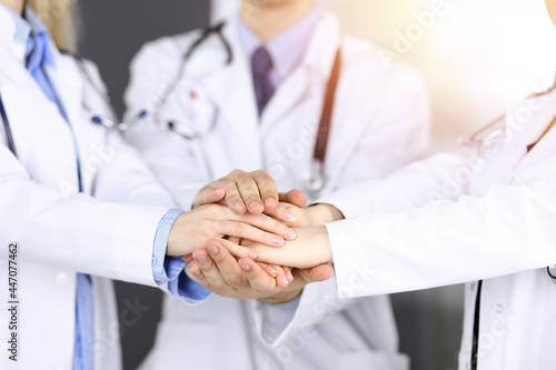 Group of modern doctors joining hands as a circle. Teamwork in medicine during Coronavirus pandemic, covid 2019