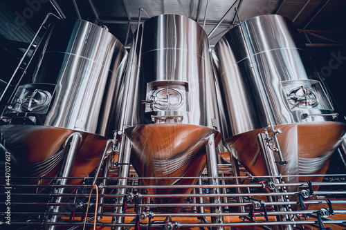 Fotografiet Rows of steel tanks for beer fermentation and maturation in a craft brewery