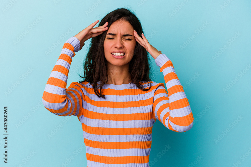Young caucasian woman isolated on blue background touching temples and having headache. Young caucasian woman isolated on blue background touching temples and having headache.