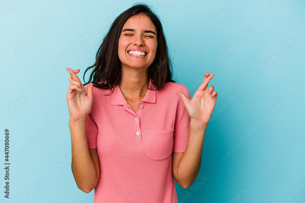 Young caucasian woman isolated on blue background crossing fingers for having luck Young caucasian woman isolated on blue background crossing fingers for having luck