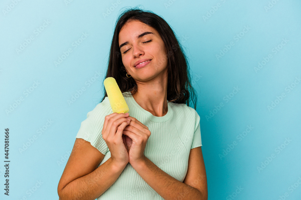 Young caucasian woman holding an ice cream isolated on blue background Young caucasian woman holding an ice cream isolated on blue background