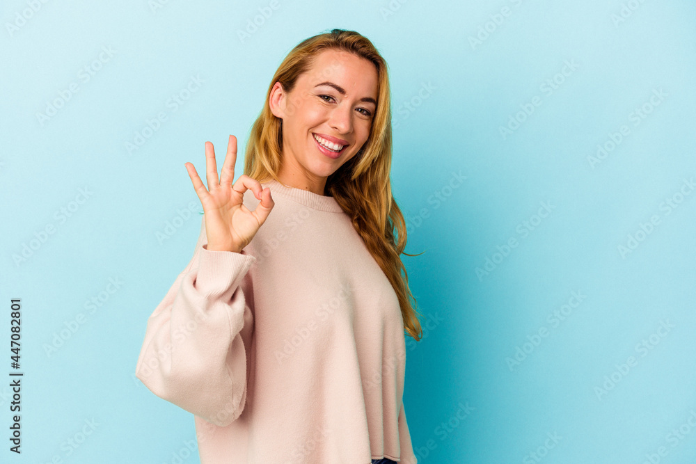 Caucasian woman isolated on blue background cheerful and confident showing ok gesture. Caucasian woman isolated on blue background cheerful and confident showing ok gesture.