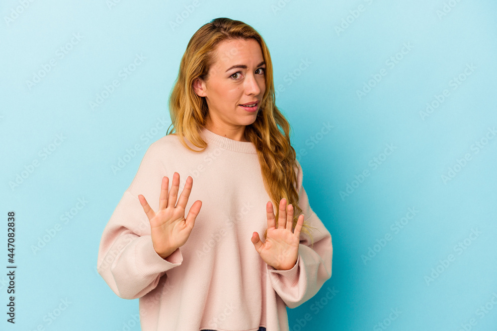 Caucasian woman isolated on blue background rejecting someone showing a gesture of disgust. Caucasian woman isolated on blue background rejecting someone showing a gesture of disgust.