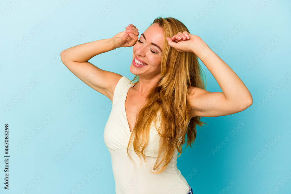 Caucasian woman isolated on blue background celebrating a special day, jumps and raise arms with energy. Caucasian woman isolated on blue background celebrating a special day, jumps and raise arms with energy.