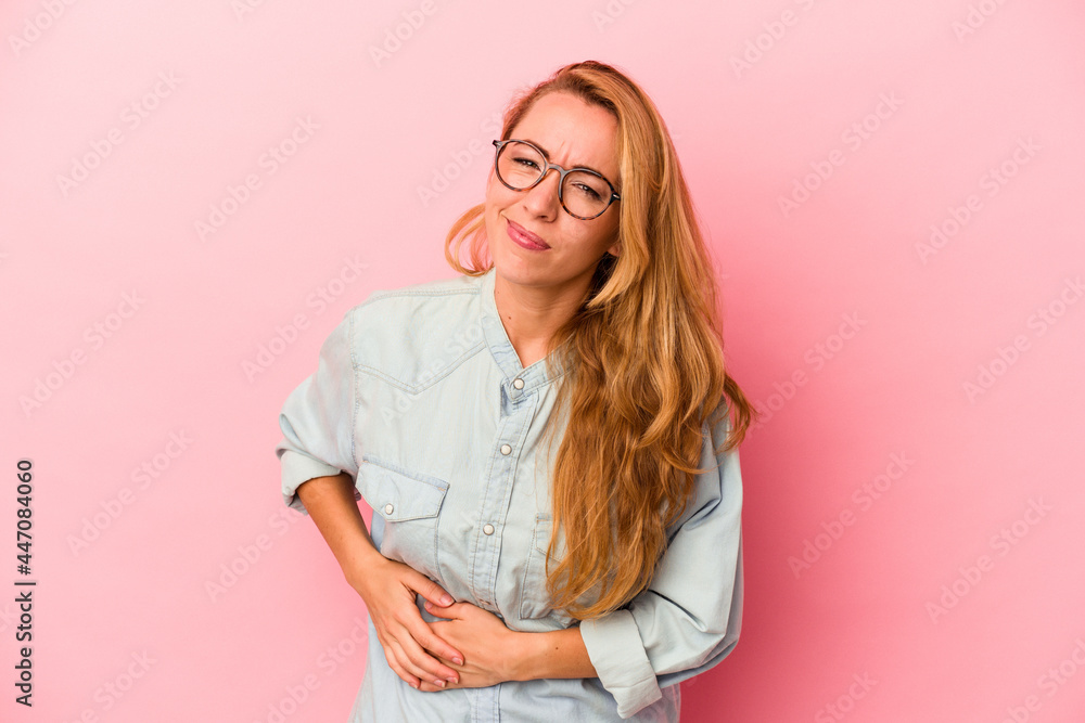 Caucasian blonde woman isolated on pink background having a liver pain, stomach ache.