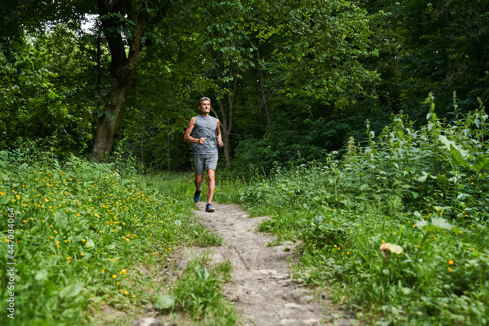 Man running with delight at the summer park and trying to keep body fit Man running with delight at the summer park and trying to keep body fit