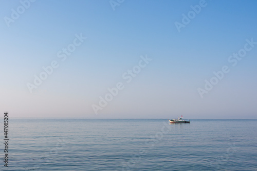 Small motor boat moored off the coast of a Turkish island in the Aegean Sea on a calm day at sunrise