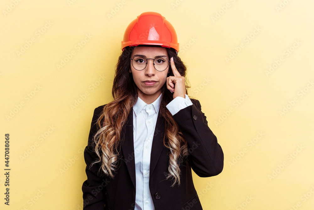 Young architect mixed race woman isolated on yellow background pointing temple with finger, thinking, focused on a task. Young architect mixed race woman isolated on yellow background pointing temple with finger, thinking, focused on a task.