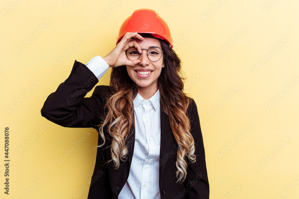 Young architect mixed race woman isolated on yellow background excited keeping ok gesture on eye. Young architect mixed race woman isolated on yellow background excited keeping ok gesture on eye.