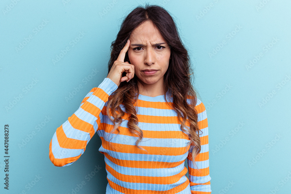 Young mexican woman isolated on blue background pointing temple with finger, thinking, focused on a task. Young mexican woman isolated on blue background pointing temple with finger, thinking, focused on a task.