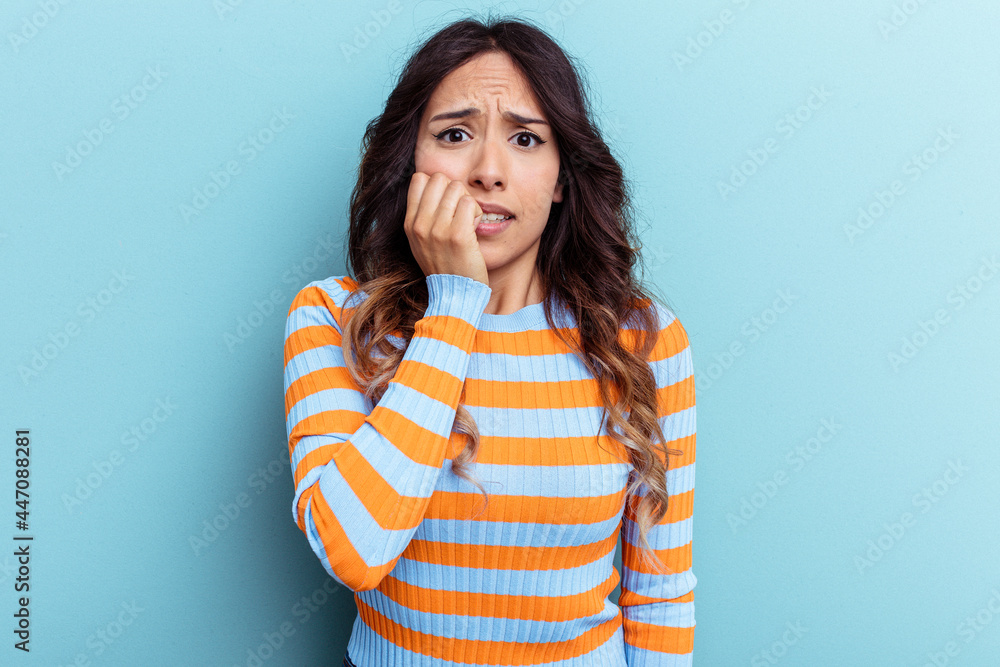 Young mexican woman isolated on blue background biting fingernails, nervous and very anxious. Young mexican woman isolated on blue background biting fingernails, nervous and very anxious.