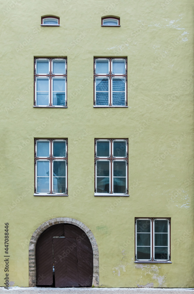 Several windows and gate on the facade of the urban historic building front view, Tallinn, Estonia
