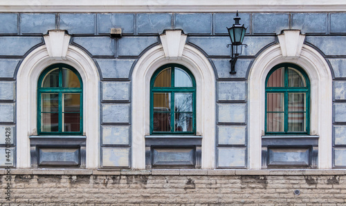Three windows in a row on the facade of the urban historic building front view, Tallinn, Estonia  © dr_verner