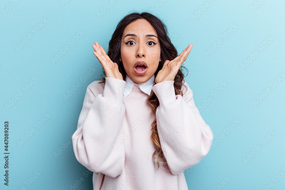 Young mexican woman isolated on blue background surprised and shocked. Young mexican woman isolated on blue background surprised and shocked.