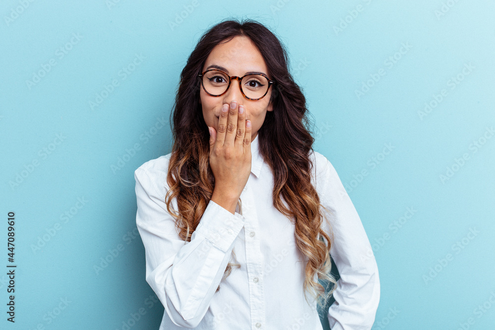 Young mexican woman isolated on blue background shocked, covering mouth with hands, anxious to discover something new. Young mexican woman isolated on blue background shocked, covering mouth with hands, anxious to discover something new.