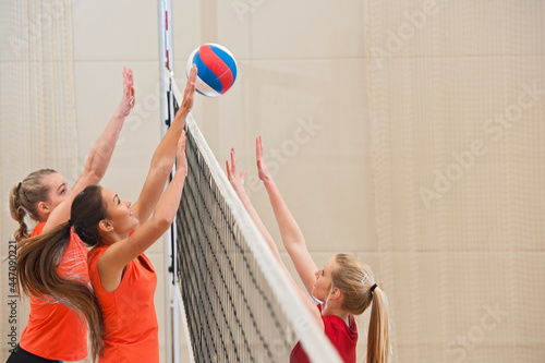 teenage girls at volleyball practise in indoor sports hall photo
