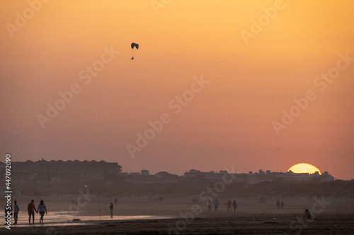 sunset on the beach of huelva with silhouettes of people