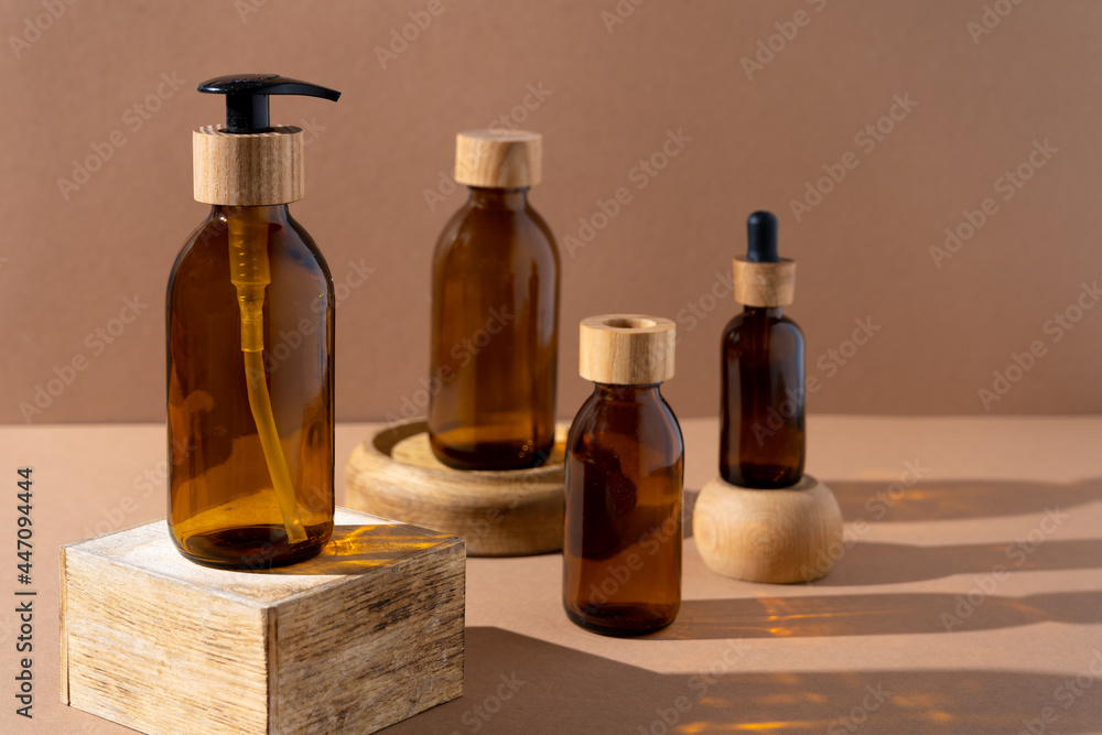 Eco friendly bottles for cosmetics. Glass bottle with a wooden lid with a dispenser and a pipette. Beauty and skin care. Brand packaging, place for text. Bottle products. Minimalism concept.