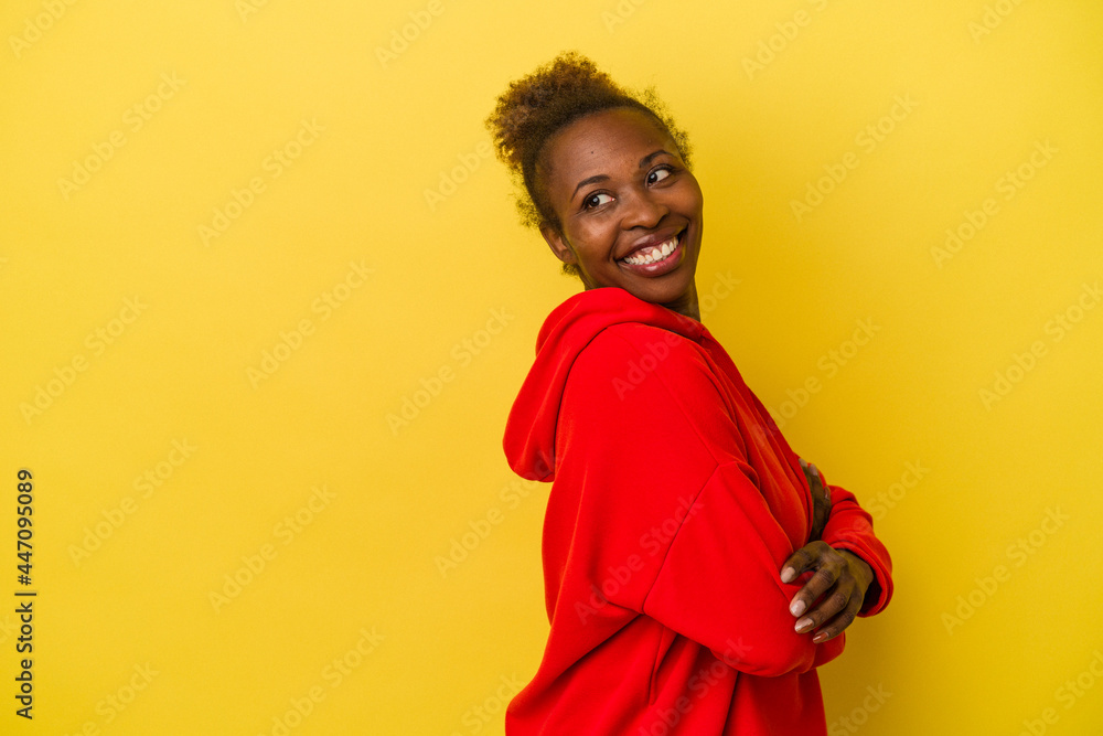 Young african american woman isolated on yellow background smiling confident with crossed arms. Young african american woman isolated on yellow background smiling confident with crossed arms.