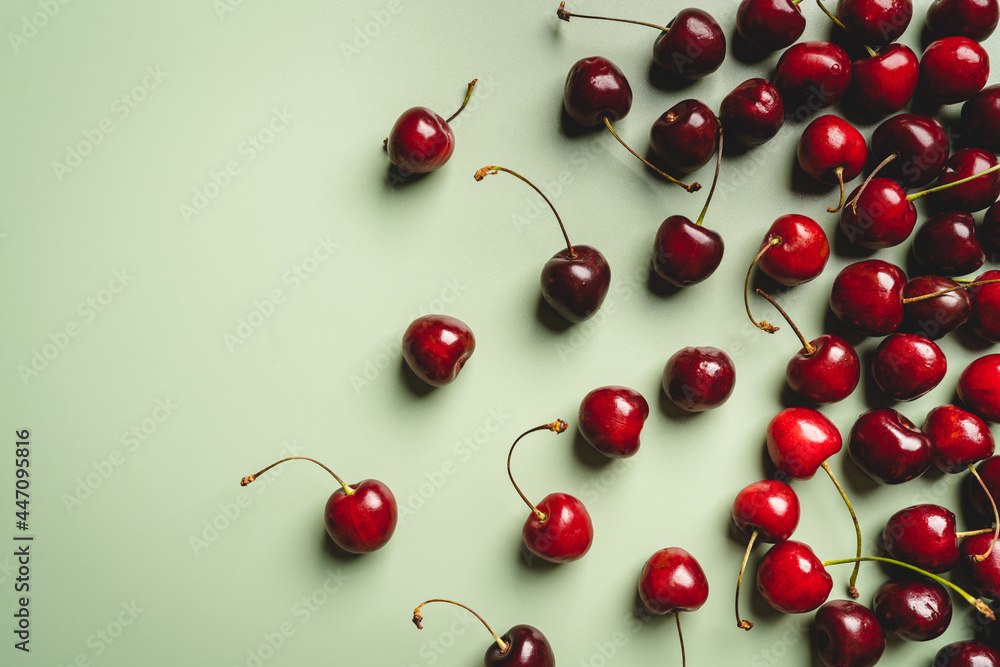 Top view of a ripe sweet cherry on green background Top view of a ripe sweet cherry on green background