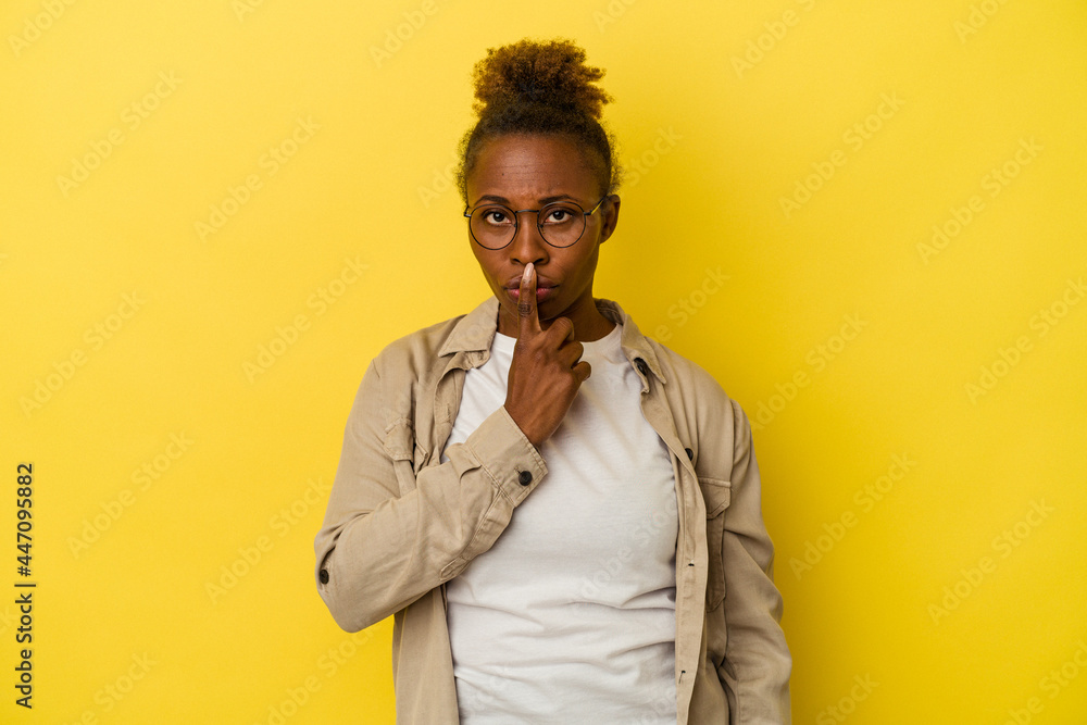 Young african american woman isolated on yellow background thinking and looking up, being reflective, contemplating, having a fantasy. Young african american woman isolated on yellow background thinking and looking up, being reflective, contemplating, having a fantasy.