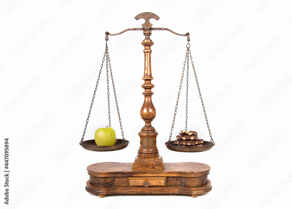 apple and chocolate on a scale as a symbol for healthy and unhealthy food apple and chocolate on a scale as a symbol for healthy and unhealthy food