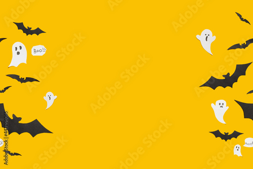 Flat lay Halloween background with decorative ghost  bats on orange backdrop. Copy space for text. Festive concept.