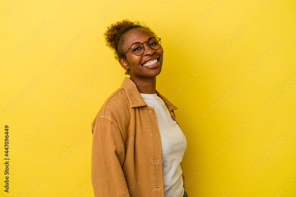 Young african american woman isolated on yellow background confident keeping hands on hips. Young african american woman isolated on yellow background confident keeping hands on hips.