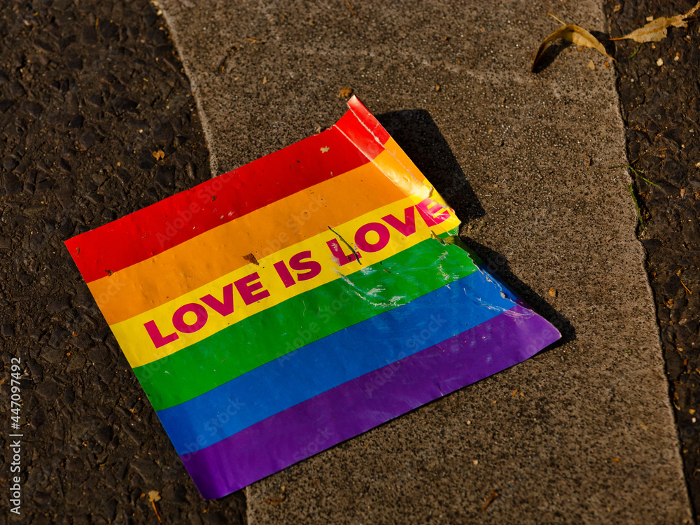 A rainbow flag lies on the ground