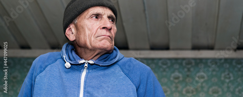 Fényképezés Mature pensioner with sourface wearing knitted cap looking aside