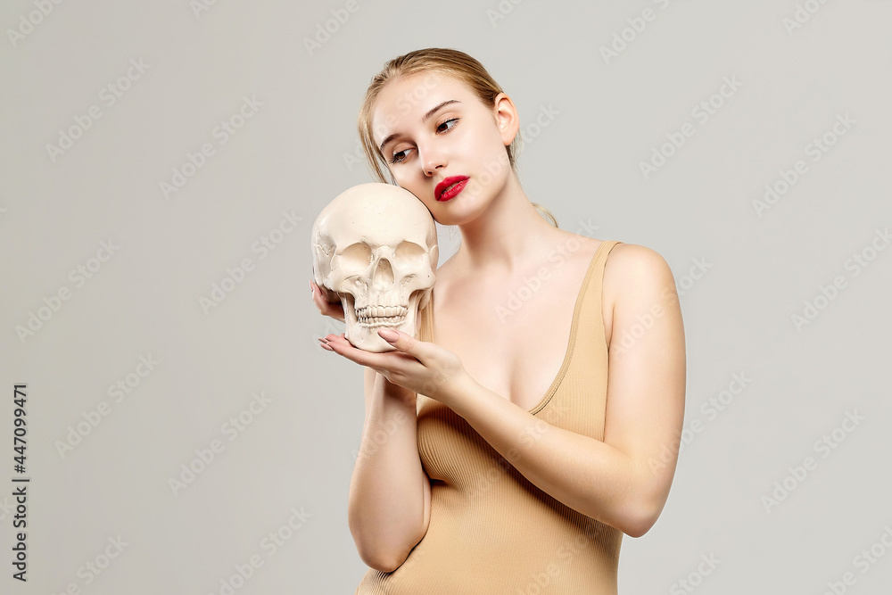 attractive blonde holds a skull in her hands. the concept of photography is suitable in the field of cosmology, medicine and healthcare attractive blonde holds a skull in her hands. the concept of photography is suitable in the field of cosmology, medicine and healthcare