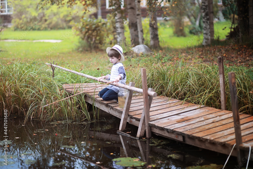 A child is fishing in the autumn morning. Autumn sunset on the pond. A fisherman with a fishing rod on the walkway. A child is fishing in the autumn morning. Autumn sunset on the pond. A fisherman with a fishing rod on the walkway.