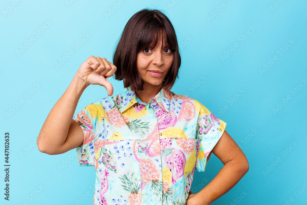 Young mixed race woman isolated on blue background showing thumb down, disappointment concept. Young mixed race woman isolated on blue background showing thumb down, disappointment concept.