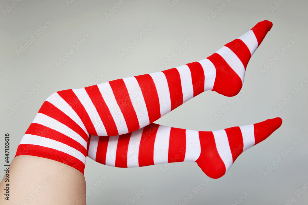 Obraz premium Female legs in Christmas knee socks. Concept of New Year celebration, woman in elf costume