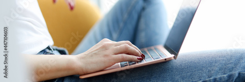 Canvastavla Woman sitting in chair with laptop on her lap closeup