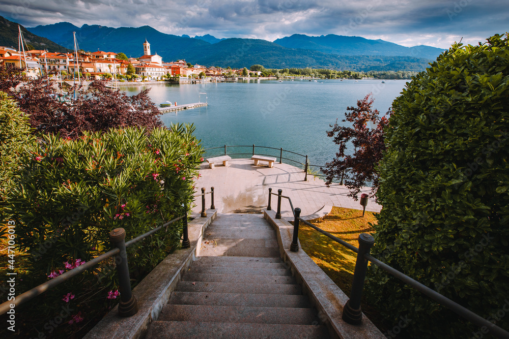 Feriolo, Verbania / Italy - June 2021: Feriolo village on Lake Maggiore with cloudy sky and steps to walk along the lake in the foreground