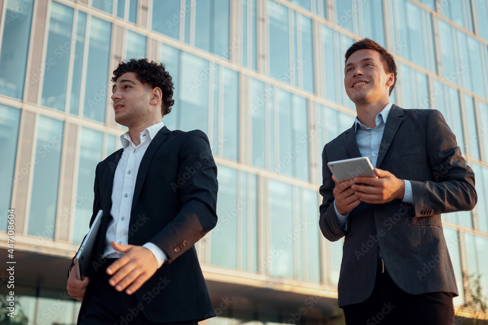 Economists are discussing further actions on the project. Business and youth concept. Men go to work brokers hold gadgets in their hands. Economists are discussing further actions on the project. Business and youth concept. Men go to work brokers hold gadgets in their hands.