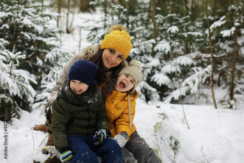 Happy family playing and laughing in winter outdoors in the snow. City park winter day.