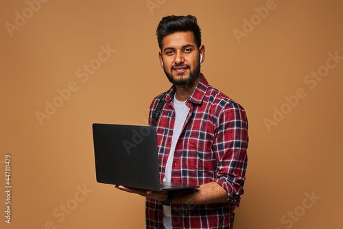 Photography Happy hindu manager in casual close with laptop on pastel background