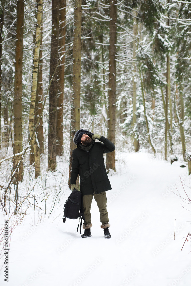 Bearded man in the winter woods. Attractive happy young man with beard walk in the park.