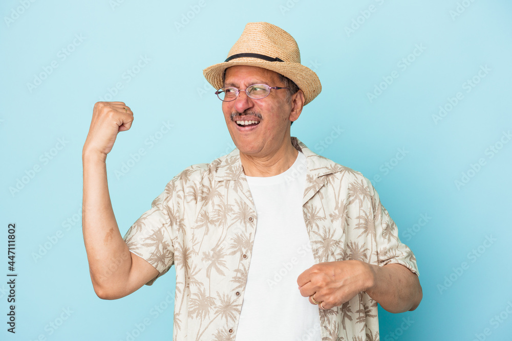 Senior indian man wearing summer clothes isolated on blue background Senior indian woman wearing a african costume isolated on white background raising fist after a victory, winner concept. Senior indian man wearing summer clothes isolated on blue background Senior indian woman wearing a african costume isolated on white background raising fist after a victory, winner concept.