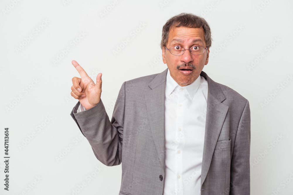 Middle aged indian business man isolated on white background pointing to the side Middle aged indian business man isolated on white background pointing to the side