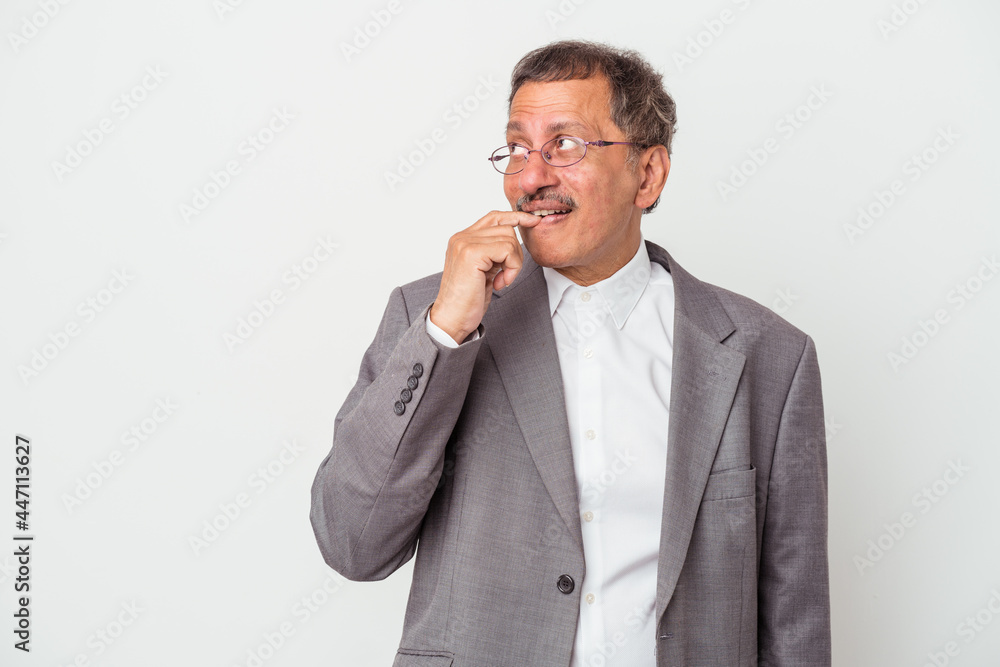 Middle aged indian business man isolated on white background relaxed thinking about something looking at a copy space.