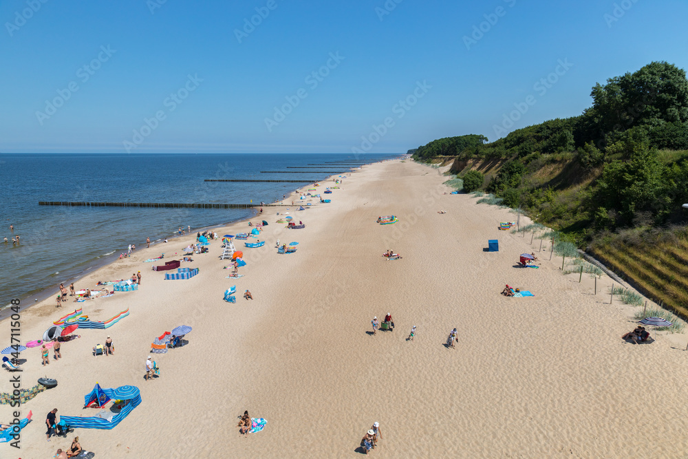 tourists relaxing on the beach, walking and sunbathing. tourists relaxing on the beach, walking and sunbathing.