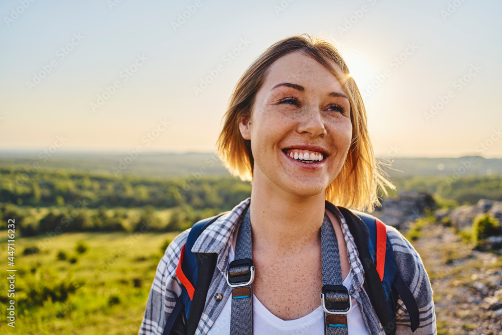 Portrait of a smiling woman hiking with backpack during summer holiday Portrait of a smiling woman hiking with backpack during summer holiday