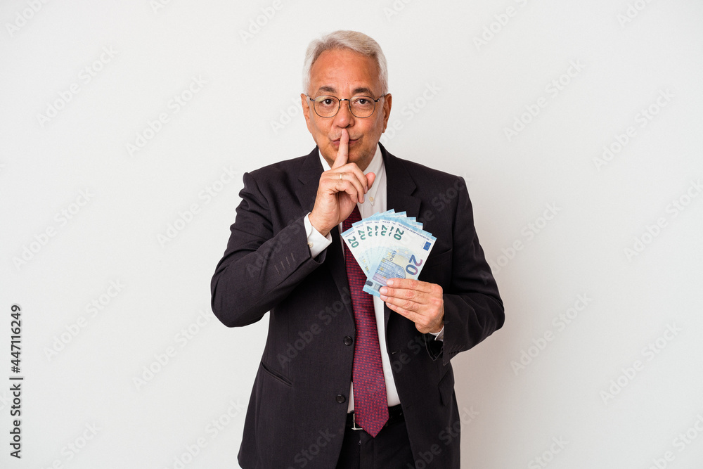 Senior american business man holding bills isolated on white background keeping a secret or asking for silence. Senior american business man holding bills isolated on white background keeping a secret or asking for silence.