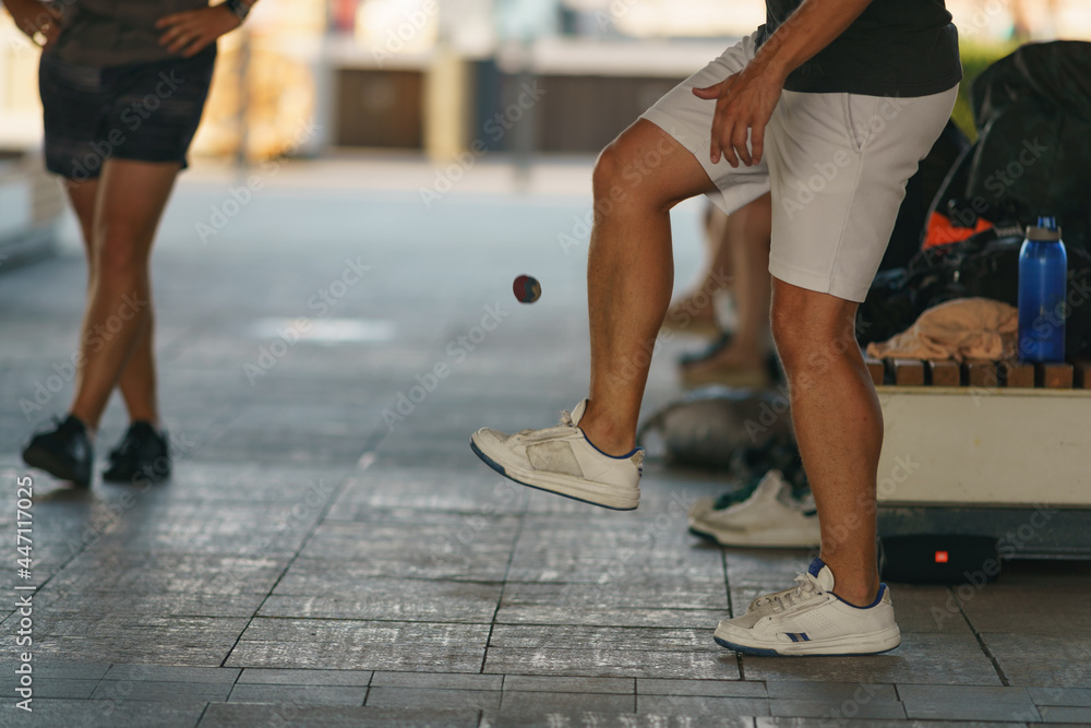 A young athlete fulfills its footbag tricks. Footbag freestyler practices  on the Moscow city street. Game with small ball is very popular among  youth. Active healthy lifestyle concept. Stock Photo | Adobe