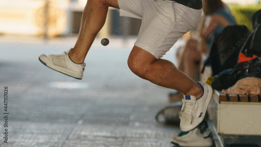 A young athlete fulfills its footbag tricks. Footbag freestyler practices on the Moscow city street. Game with small ball is very popular among youth. Active healthy lifestyle concept.